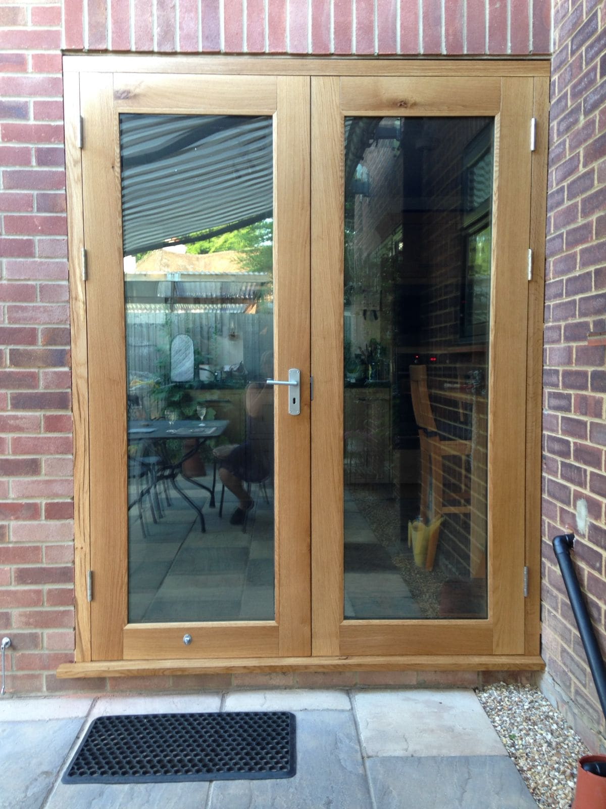 Pair of glazed oak French doors in a brick opening