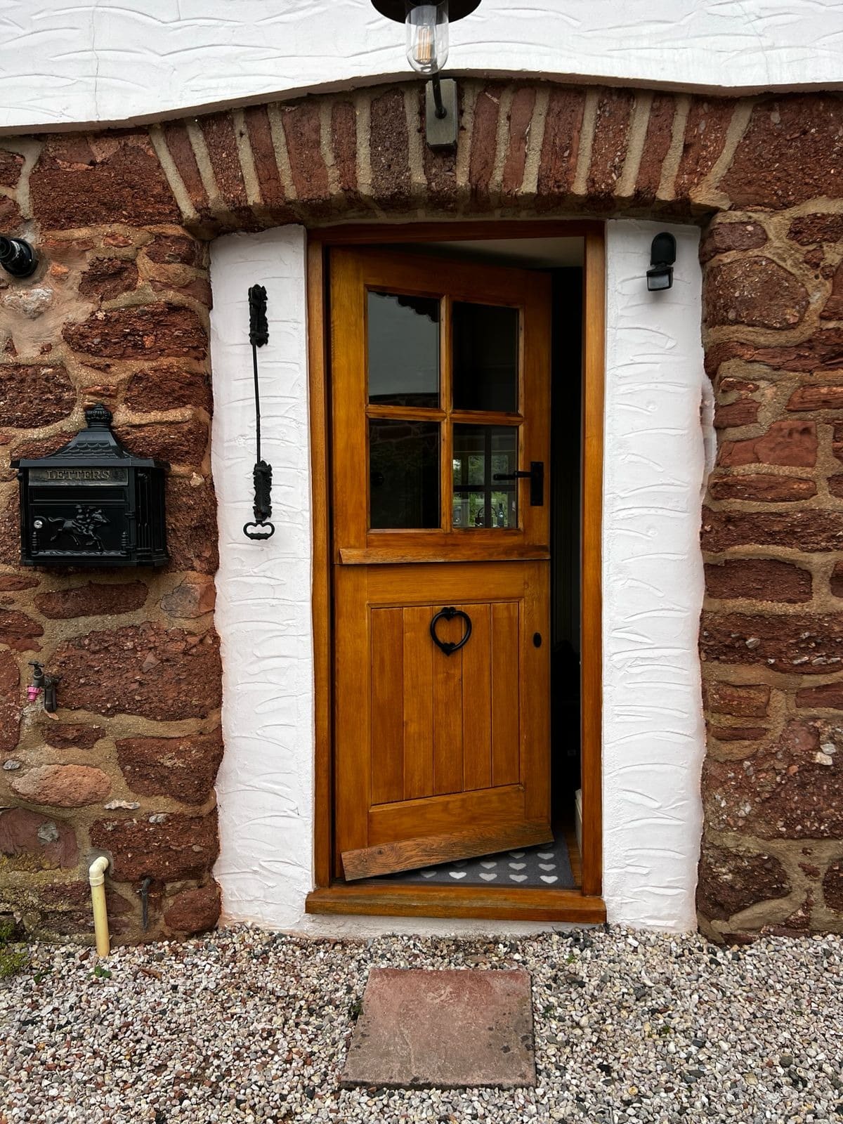 Oak stable door with a glazed upper leaf in a sandstone cottage wall