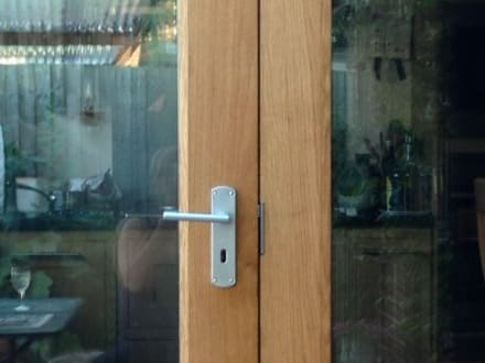 Lever handle on the meeting stiles of glazed oak French doors