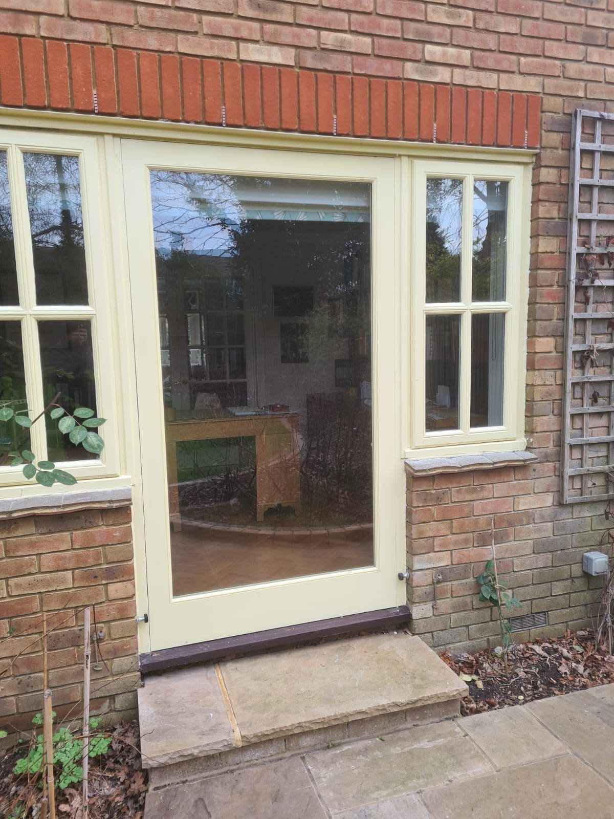 Painted glazed door made to line up with the casement windows either side