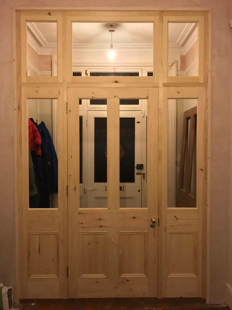 Glazed timber screen and door across a period hallway