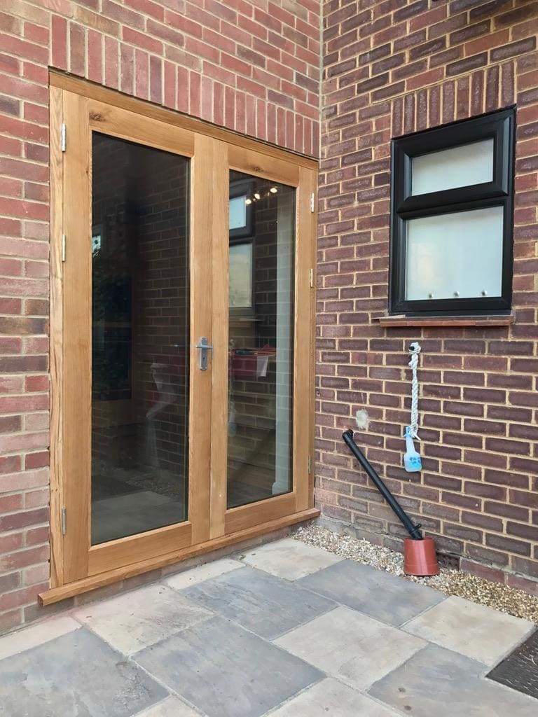 Oak French doors in a brick extension beside a casement window