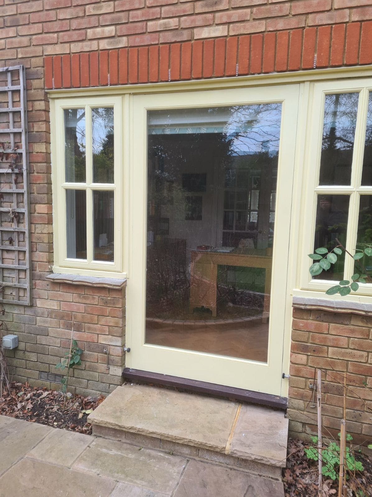 Painted fully glazed garden door between matching casement windows