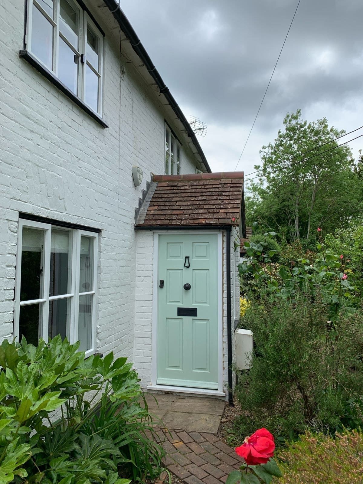 Painted bespoke timber front door on a white cottage