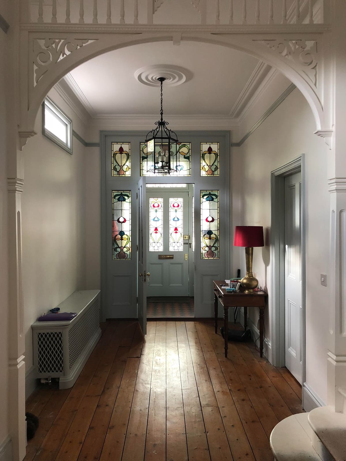 Character hallway leading towards a stained glass entrance