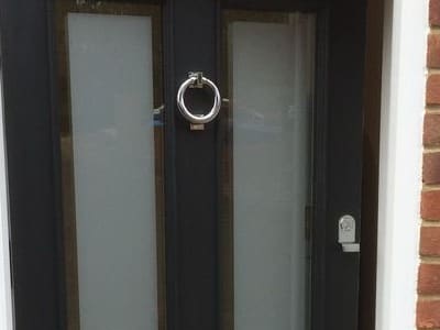 Ring knocker between glazed upper panels on a painted Victorian door