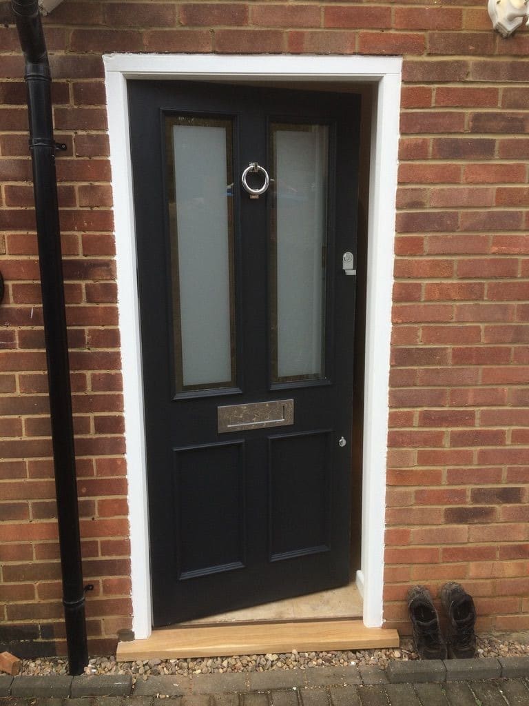 Half-glazed four-panel door, painted, with ring knocker