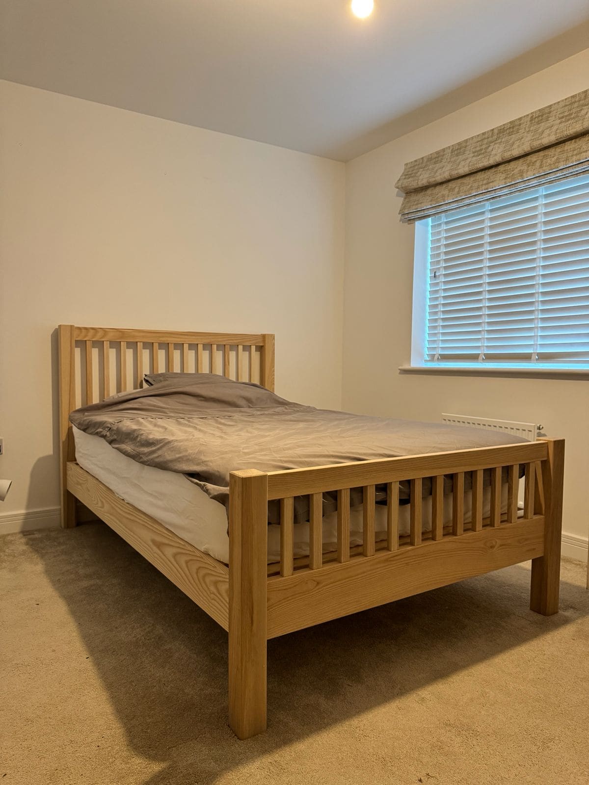 Solid oak bed frame in a bright bedroom