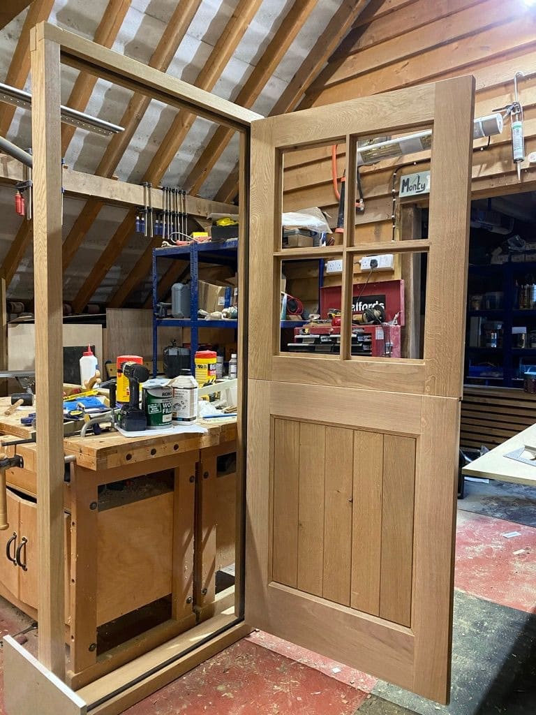 Oak stable door with a glazed upper leaf in its frame at the workshop