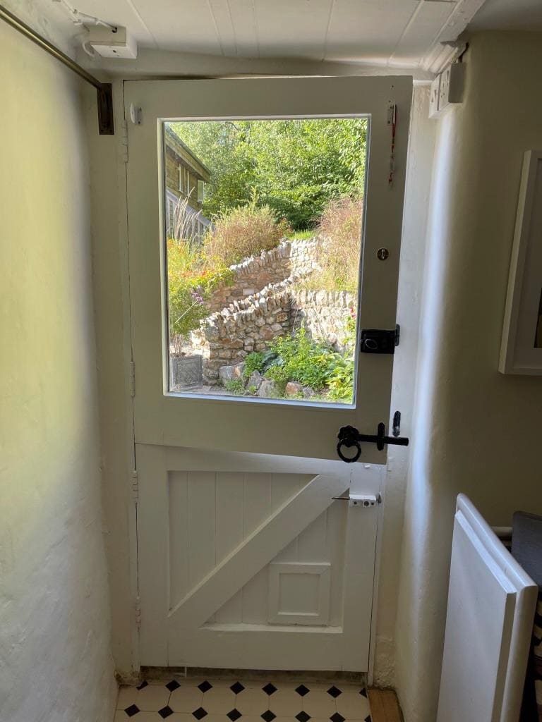 Painted ledged and braced stable door with a glazed upper leaf, seen from inside