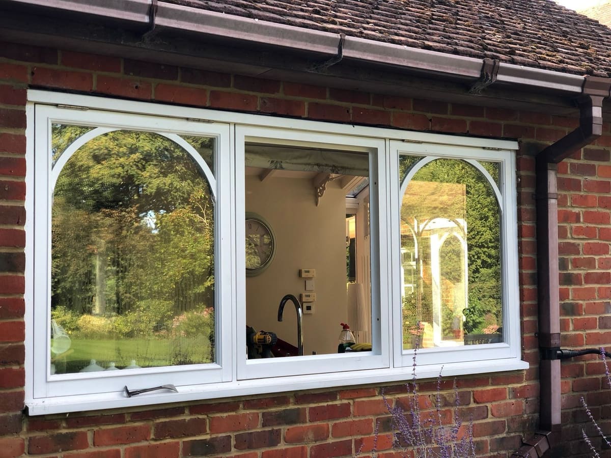 Painted bespoke timber casement windows set into the wall of a period house